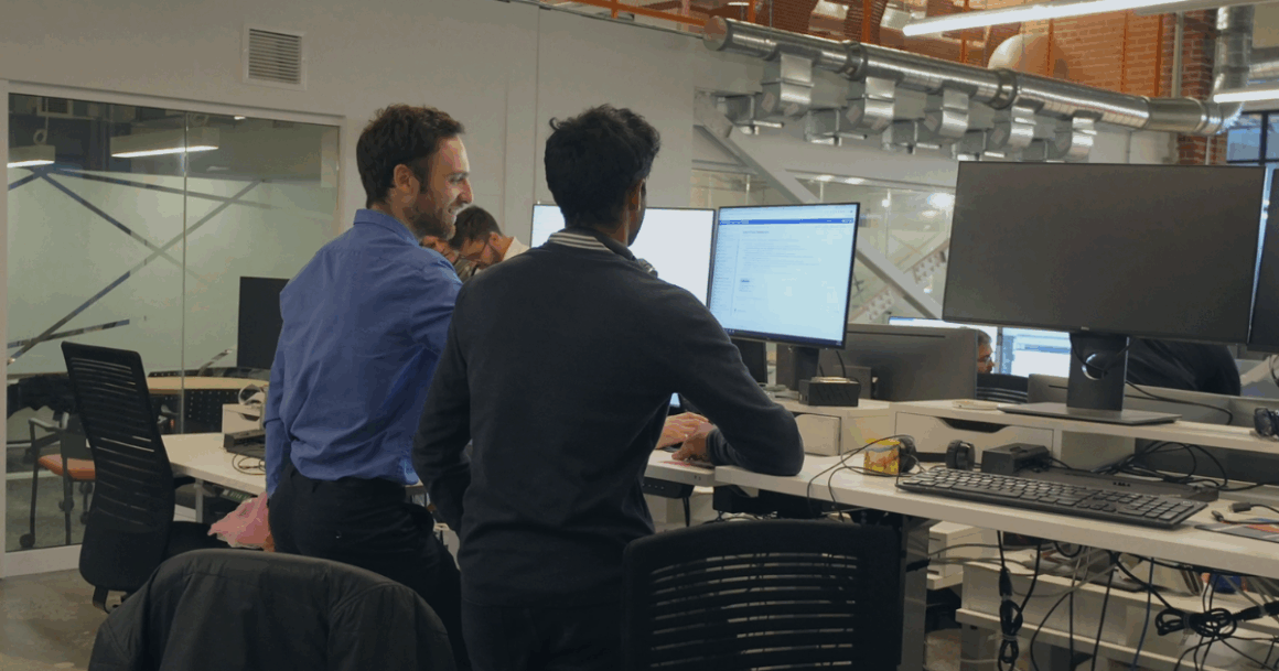 Two OPAL-RT engineers collaborating at computer monitors while testing real-time power system simulations.