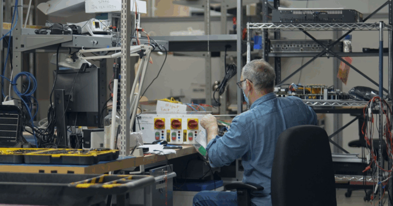 Engineer building real-time power simulation hardware for SPS integration in the OPAL-RT laboratory.